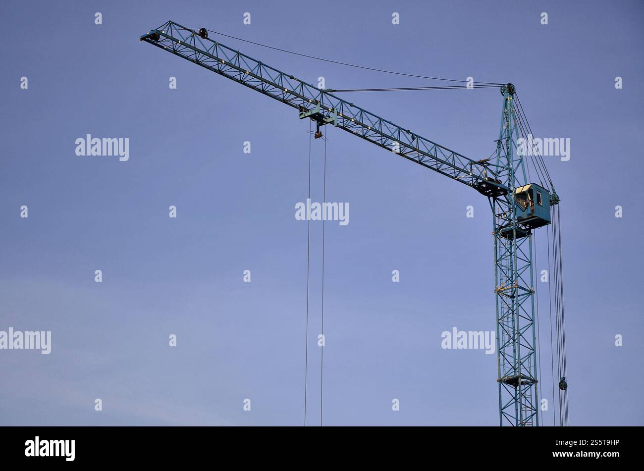 Sfondo industriale astratto con gru a torre da costruzione su un cielo blu chiaro. Cantiere. Edificio in fase di costruzione con Foto Stock