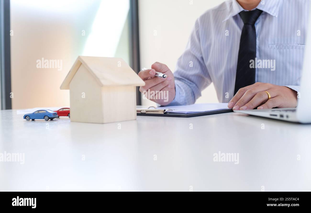 Sales Manager per dare consigli modulo di applicazione documento, considerando mutuo ipotecario speciali per auto e assicurazione casa Foto Stock