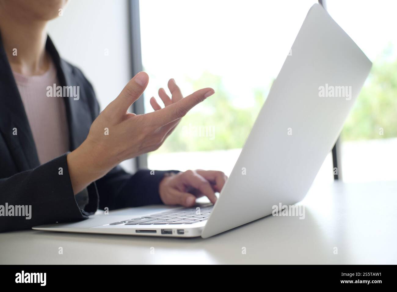 Uomo al lavoro utilizzando un computer portatile su un tavolo di legno. Mani digitando su una tastiera. Foto Stock