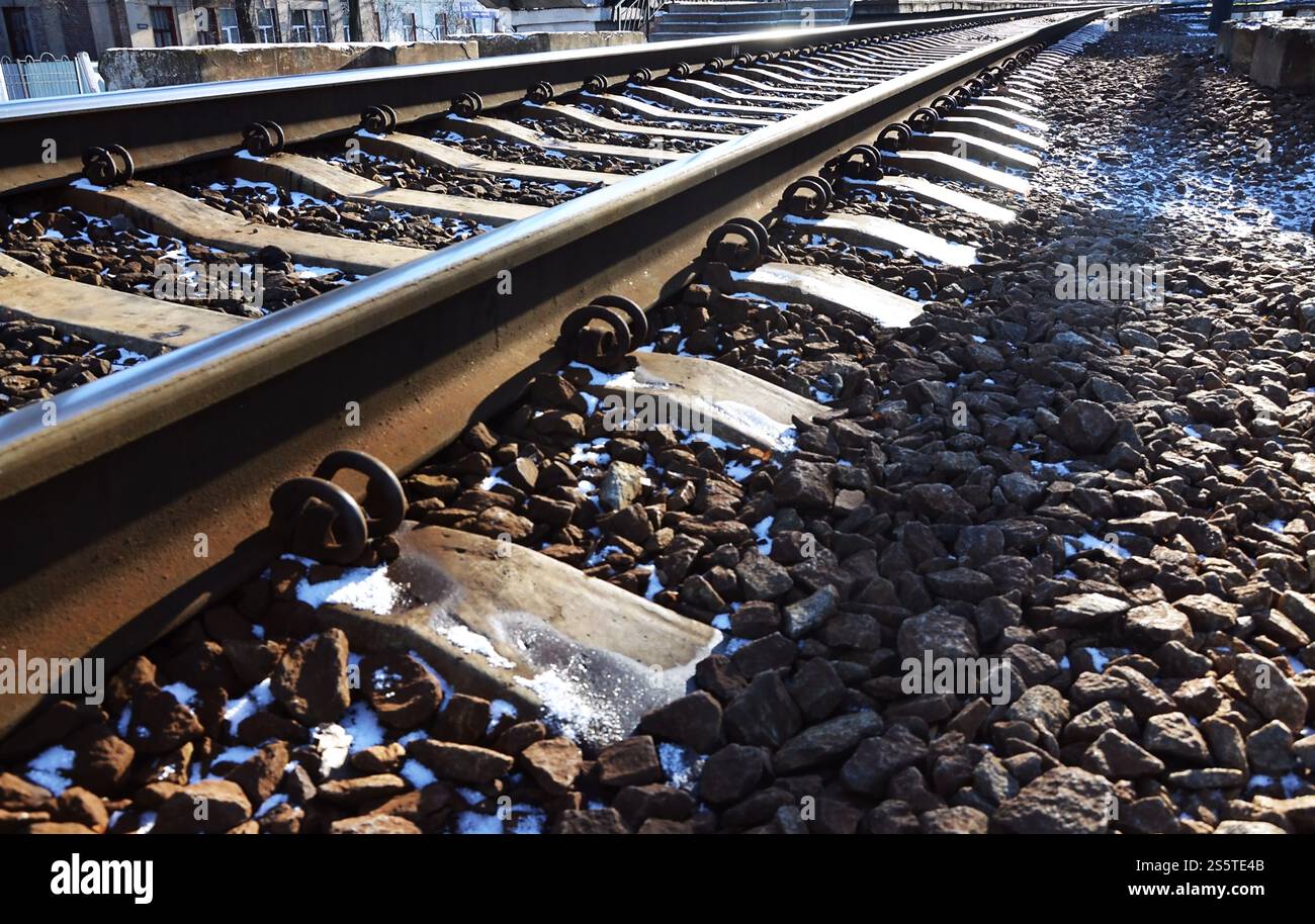 Dettagli della ferrovia invernale russa innevata sotto la luce del sole. Le rotaie e le traversine sotto la neve di dicembre. Ferrovie russe in dettaglio. Inverno Foto Stock