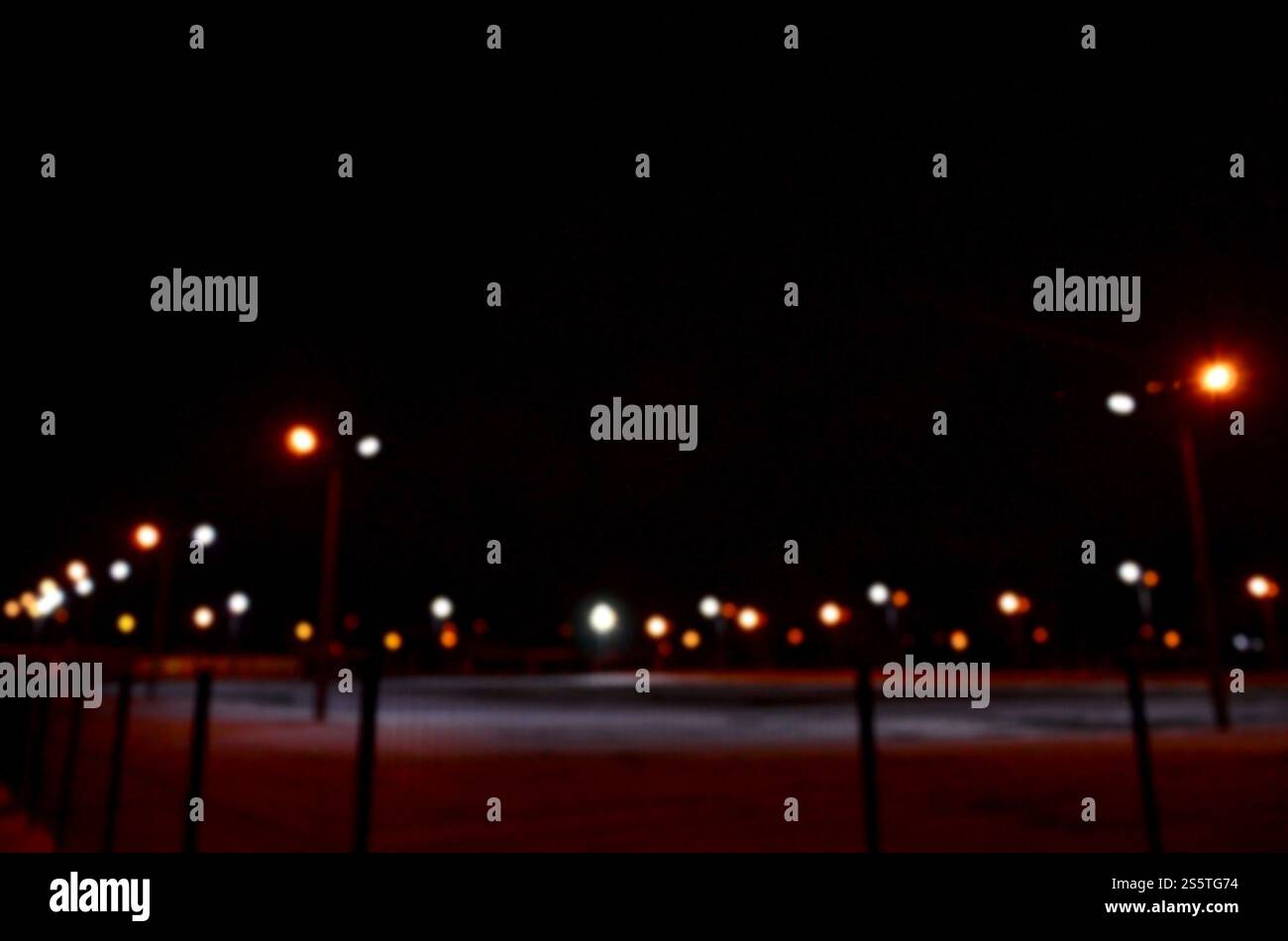 Foto sfocate del parco giochi della scuola di notte con luci accese Foto Stock