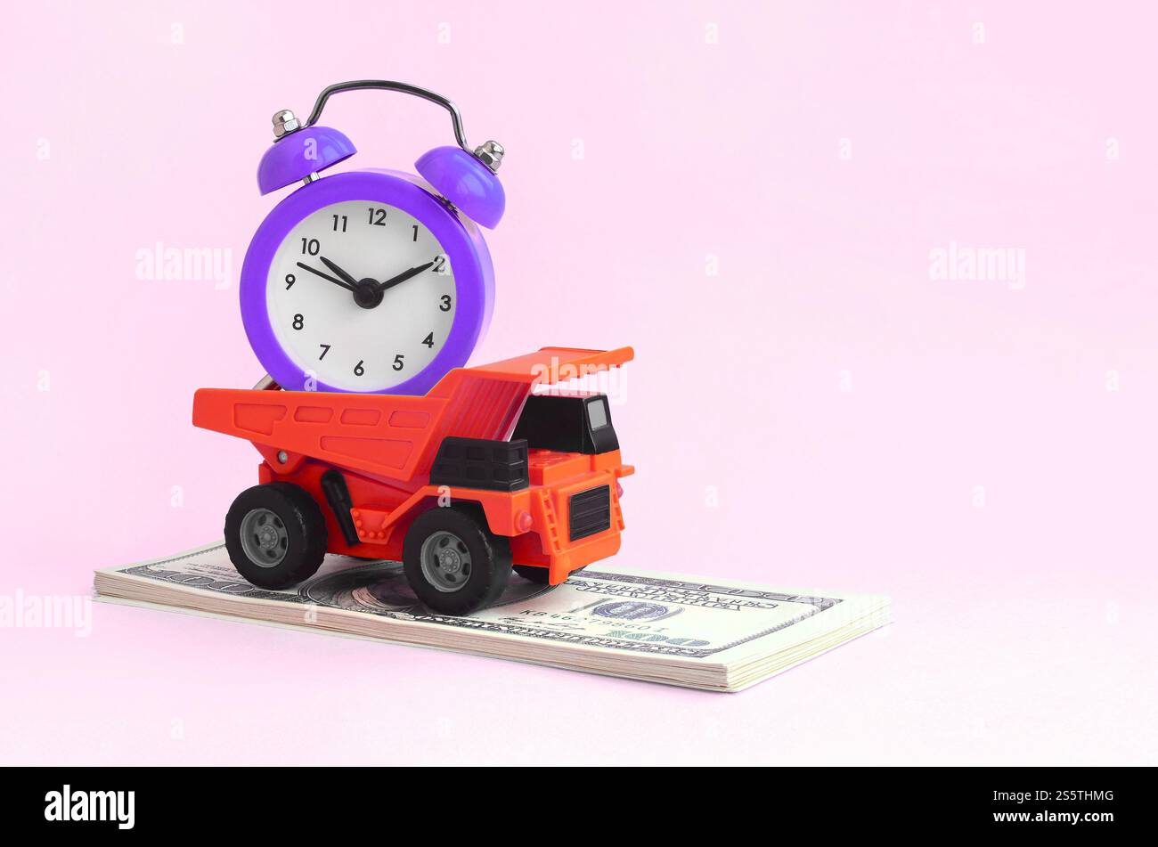 Un autocarro carico di sveglia è su una banconota da un dollaro. Il concetto di ottimizzazione e gestione razionale del tempo. Risparmio di tempo e. Foto Stock