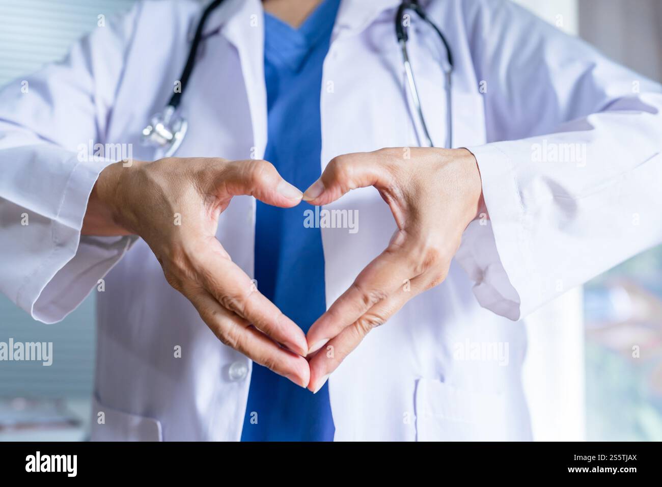 Medico cardiologo che mostra il simbolo del cuore con amore per le mani e sostegno ai pazienti Foto Stock