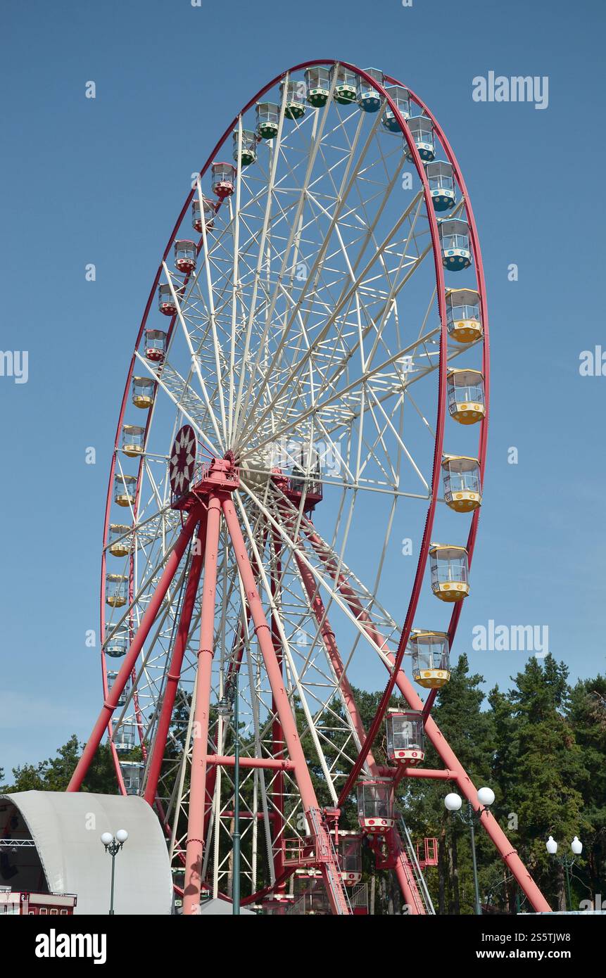 Grande e moderno multicolor ruota panoramica sul pulito cielo blu sullo sfondo Foto Stock