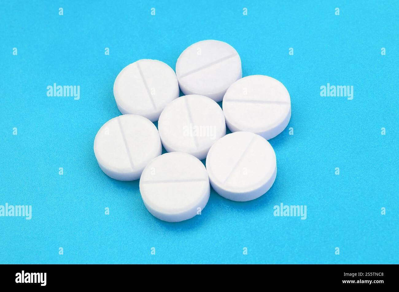 Un paio di compresse bianche giacciono su un blu brillante superficie di sfondo. Immagine di sfondo sul farmaceutico e medico, argomenti Foto Stock