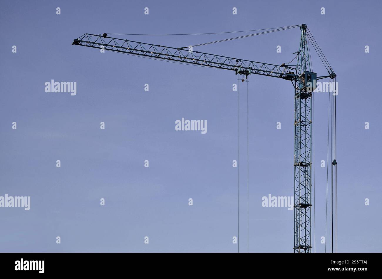 Sfondo industriale astratto con gru a torre da costruzione su un cielo blu chiaro. Cantiere. Edificio in fase di costruzione con Foto Stock