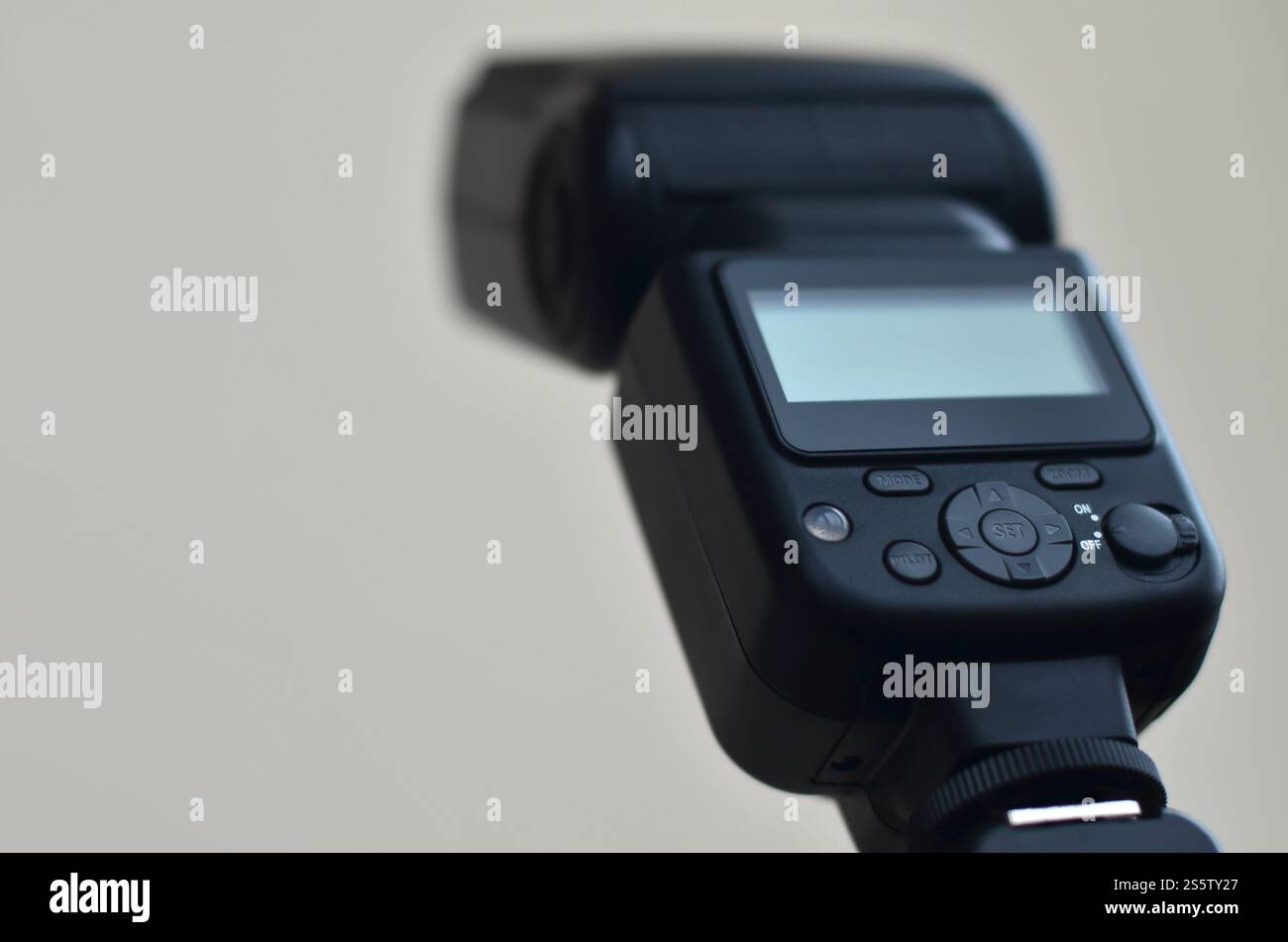 Il flash fotografico esterno è montato sul sincronizzatore, che si trova su un treppiede. oggetti dell'attrezzatura di illuminazione. Set di studi professionali Foto Stock