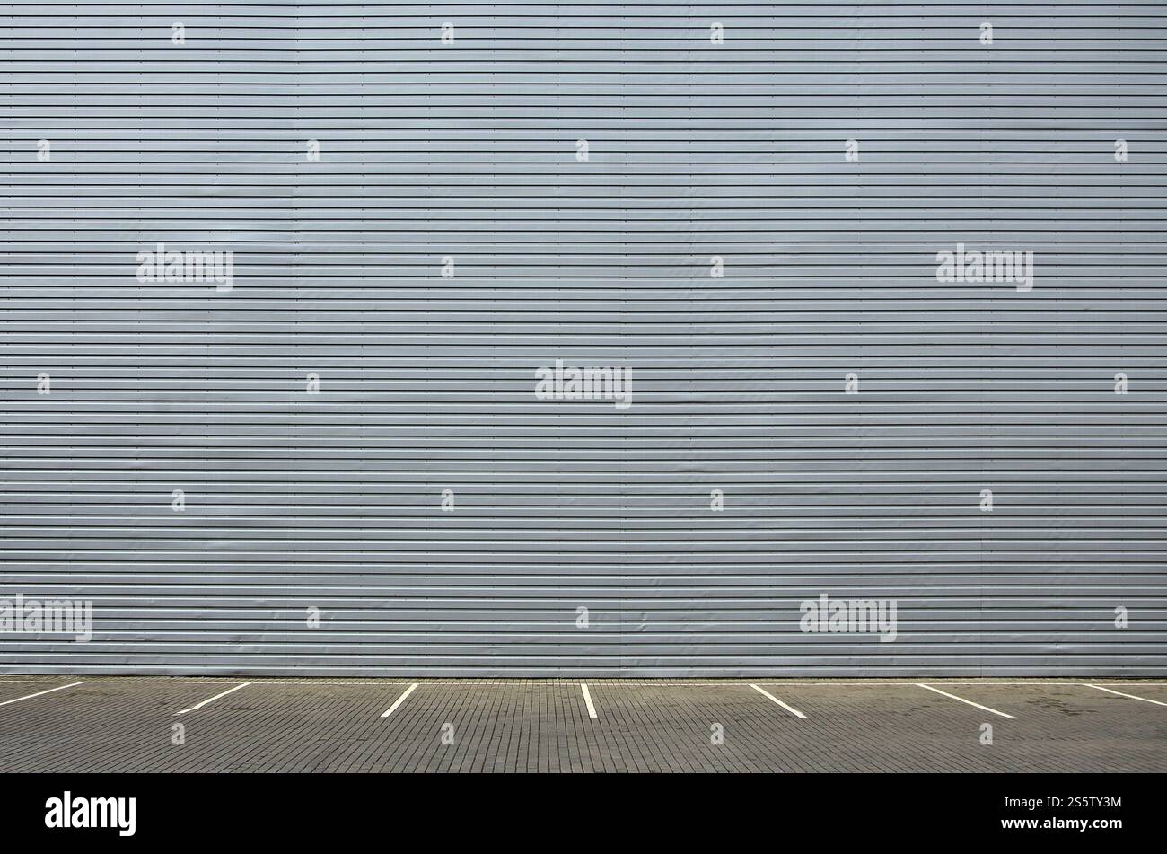 Posti auto vuoti sullo sfondo di una parete di metallo con ampio spazio libero per il posizionamento dei prodotti relativi a meccanici e automobili. Parcheggio vuoto Foto Stock