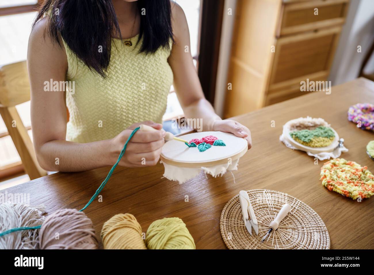 Punzonare l'ago. Donna asiatica che fa maglieria Hobby fatta a mano in laboratorio. Design Workplace Artigianato progetto artigianale fai da te concetto di ricamo Foto Stock