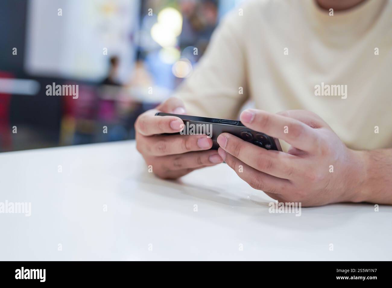 Uomo che gioca al telefono cellulare. Giocatore che gioca ai videogiochi con smartphone che lavorano su dispositivi mobili. e-commerce con tecnologia dei telefoni cellulari Foto Stock