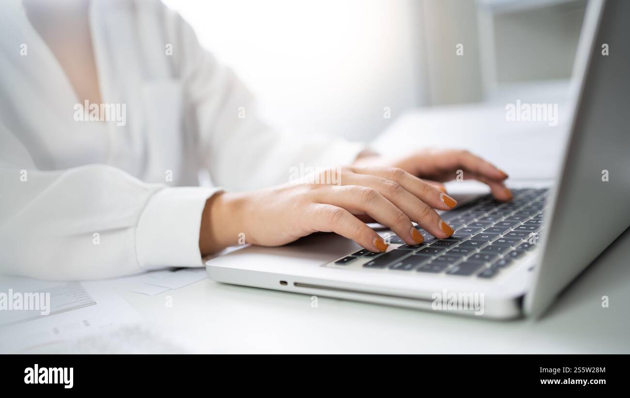 Donna che lavora utilizzando un computer portatile e digita le mani sulla tastiera. scrivere un blog. Lavorare a casa è a portata di mano macchina da scrivere. Foto Stock