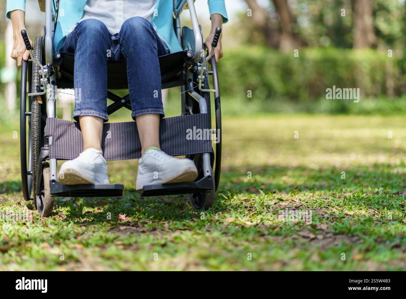 Giovane donna asiatica in sedia a rotelle con pensiero positivo Foto Stock