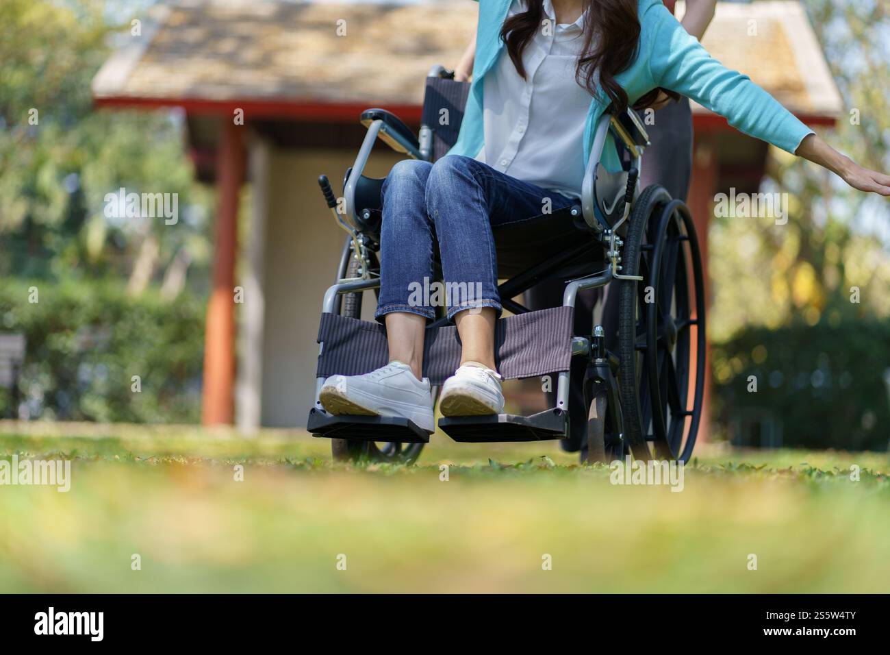 Giovane donna asiatica in sedia a rotelle con pensiero positivo Foto Stock