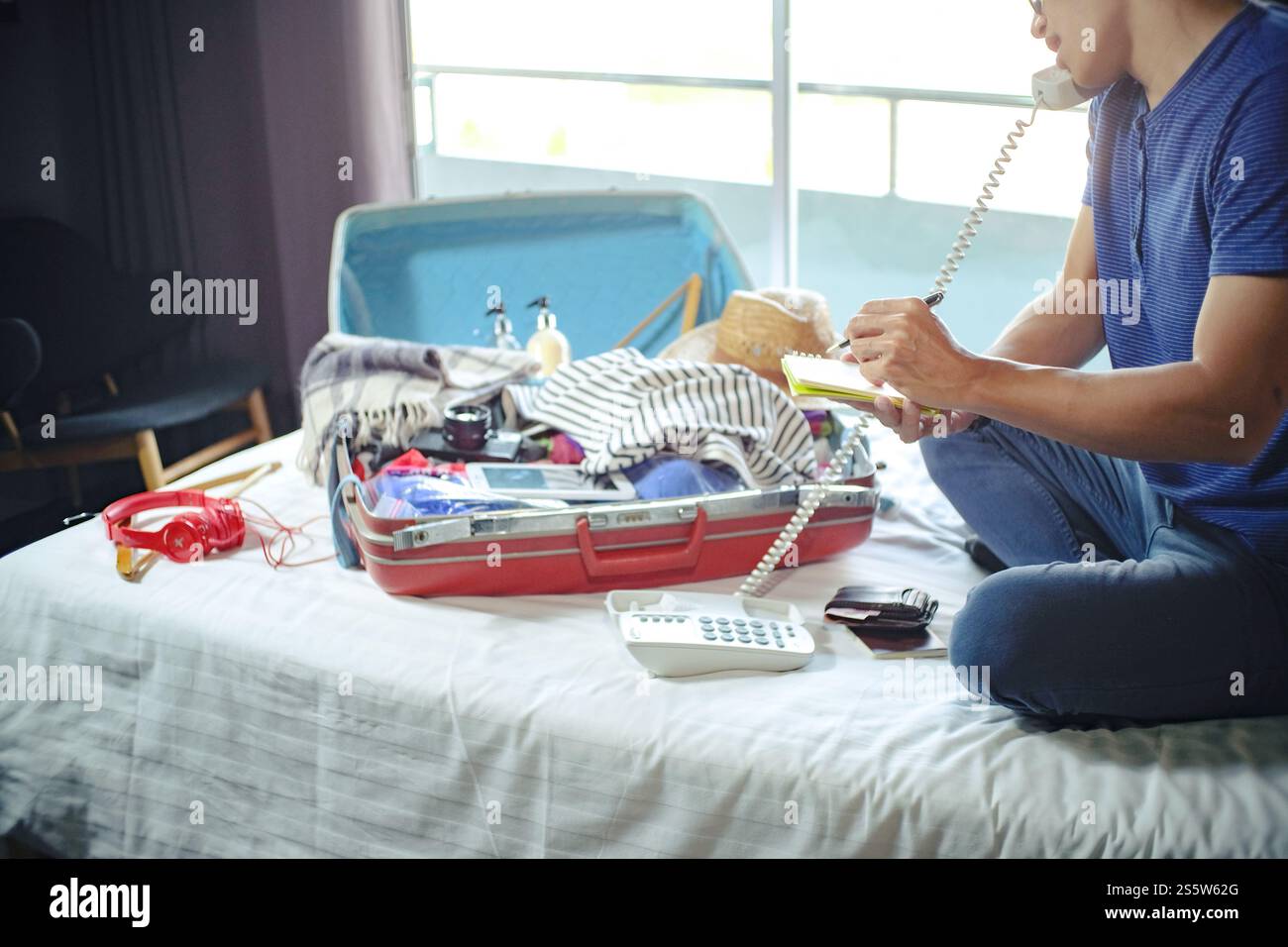 Uomo che prepara la lista dei bagagli per pianificare il viaggio, preparare le vacanze Prenota ora viaggiare trasporti Foto Stock