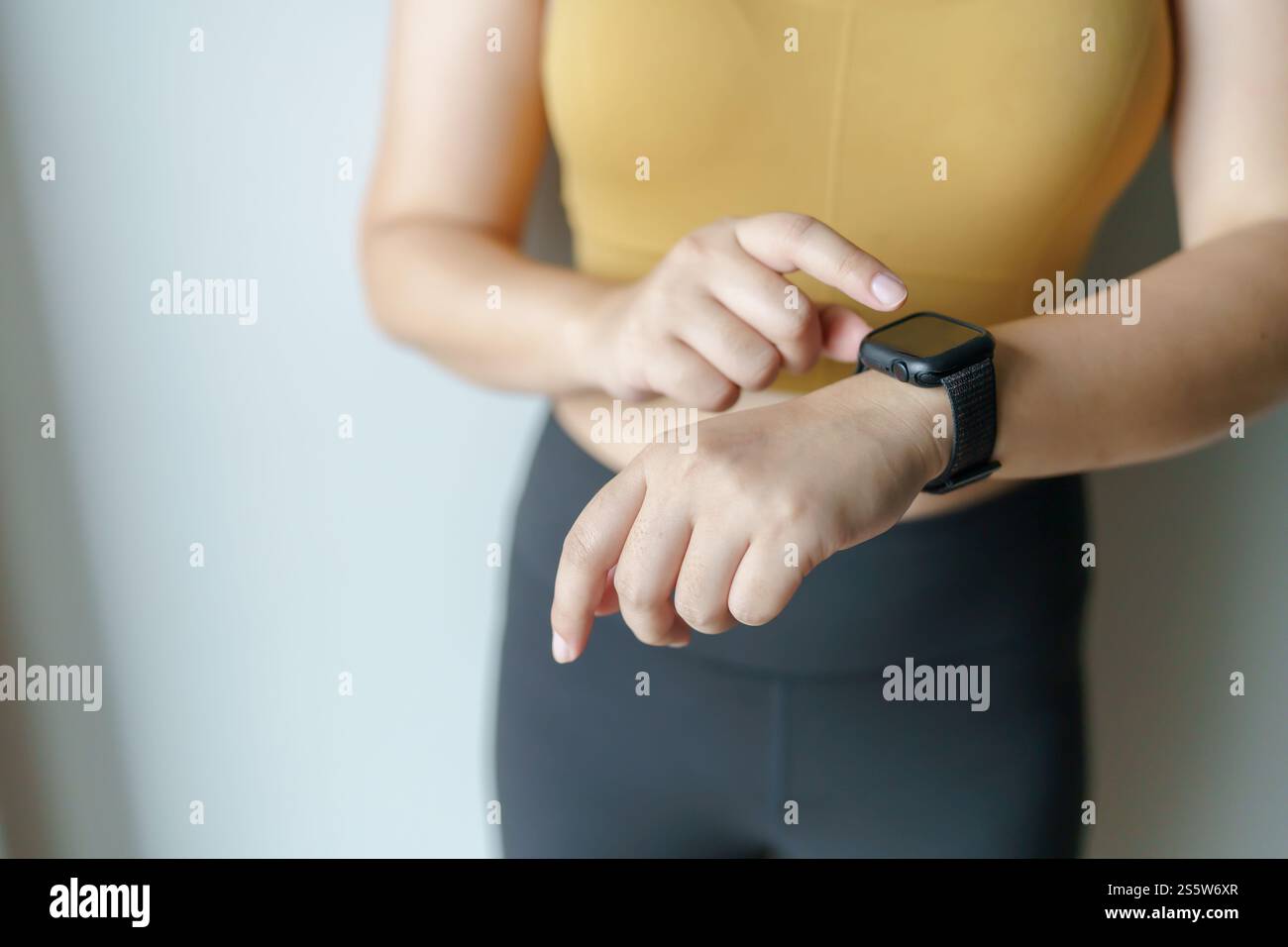 Donna che si allena con l'app salute su mani di primo piano dell'orologio intelligente. Foto Stock