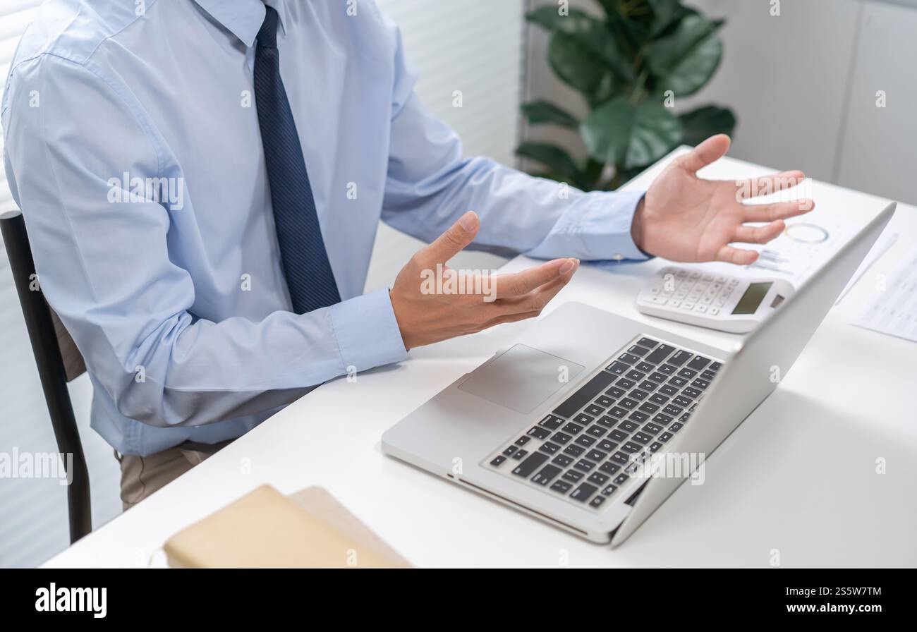L'addetto alla conferenza VDO lavora da casa. Parla chat online in videochiamata su laptop webcam conferenza uomo d'affari asiatico che lavora online e learning e. Foto Stock