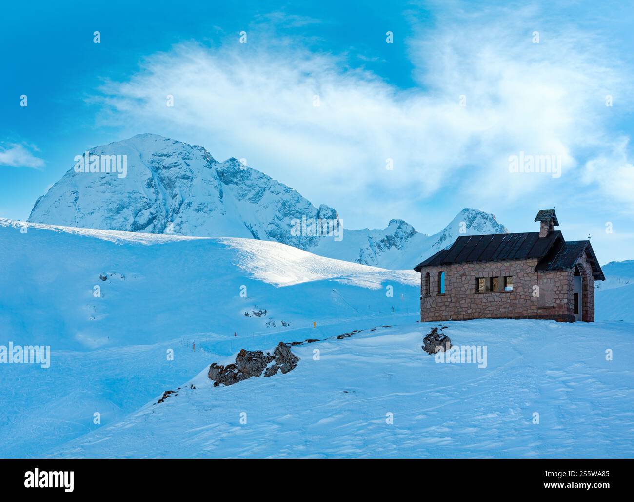 Splendida vista invernale dal passo Pordoi (Dolomiti italiane) con cappella in cima alla collina. Foto Stock