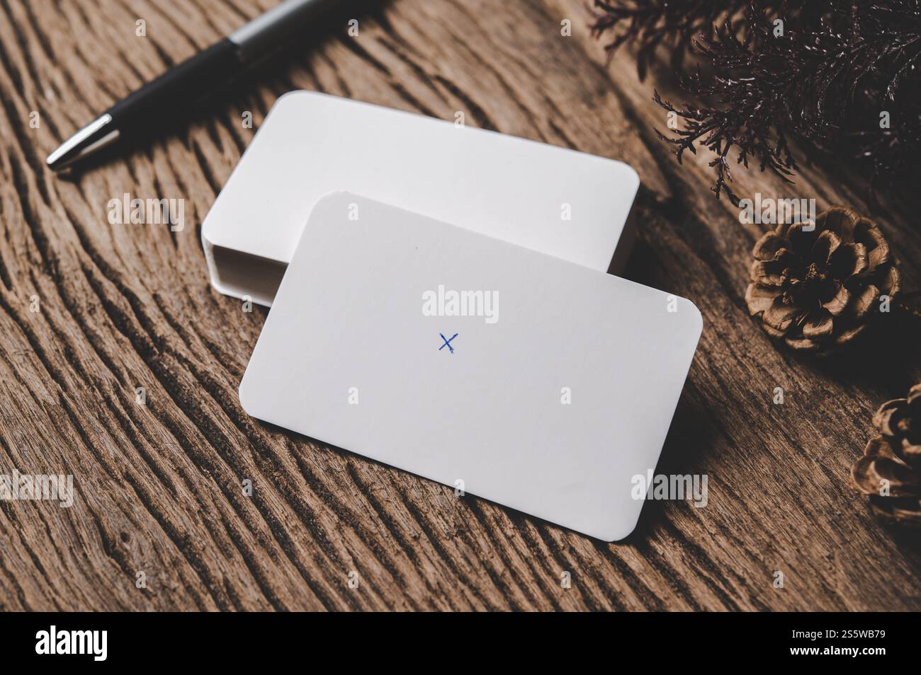 la scheda vuota e la penna sono collocate su sfondo in legno Foto Stock