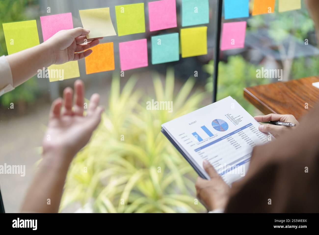 Il personale aziendale che lavora su appunti appunti appunti che scrivono idee in post IT prende nota dell'avvio di progetti da parte di investitori professionali Foto Stock