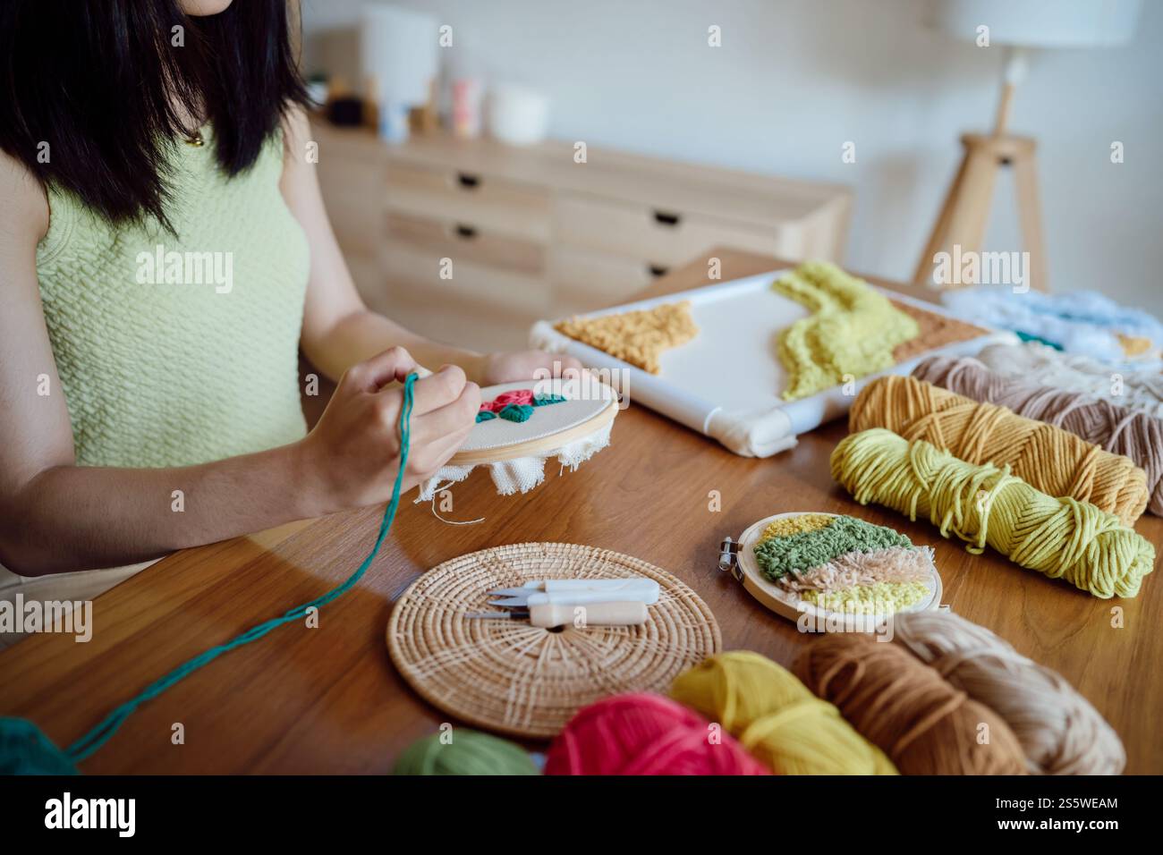 Punzonare l'ago. Donna asiatica che fa maglieria Hobby fatta a mano in laboratorio. Design Workplace Artigianato progetto artigianale fai da te concetto di ricamo Foto Stock