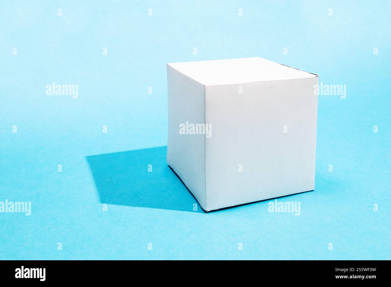 un cubo di carta realizzato a mano su sfondo blu turchese con spazio copiato Foto Stock