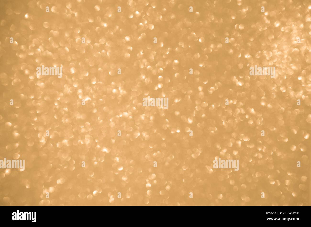 Sfondo dorato scintillante. Le luci spot sfocate scintillanti hanno una texture dorata brillante Foto Stock
