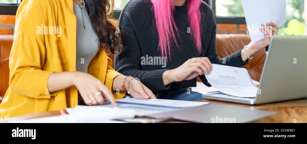 LGBTQ+ transgender uomo bellissimo autentico Specialista con capelli rosa e trans non binari che lavorano insieme Design nel team creativo del luogo di lavoro Foto Stock
