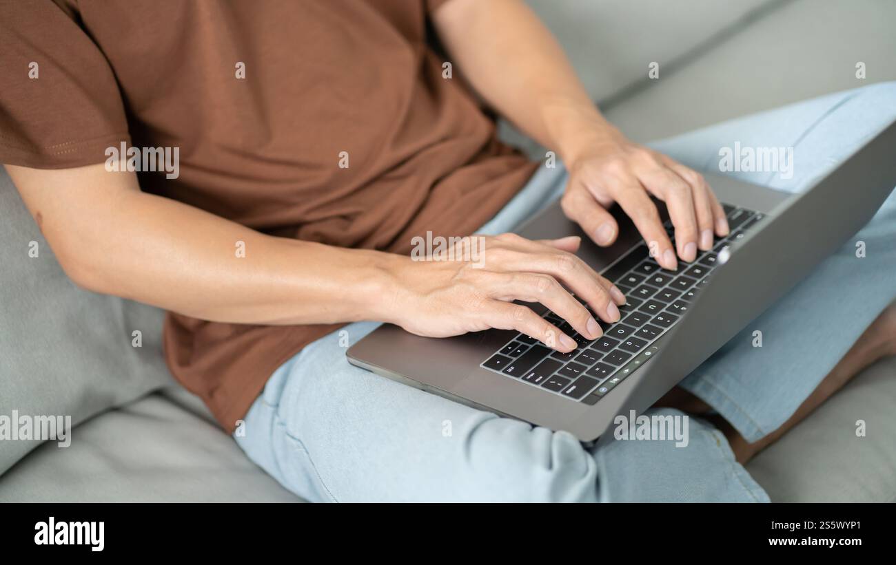 Un uomo lavora da casa. lavora online su un notebook. Uomo d'affari asiatico che lavora sul concetto di business online con riunioni online su laptop per il distanziamento sociale Foto Stock