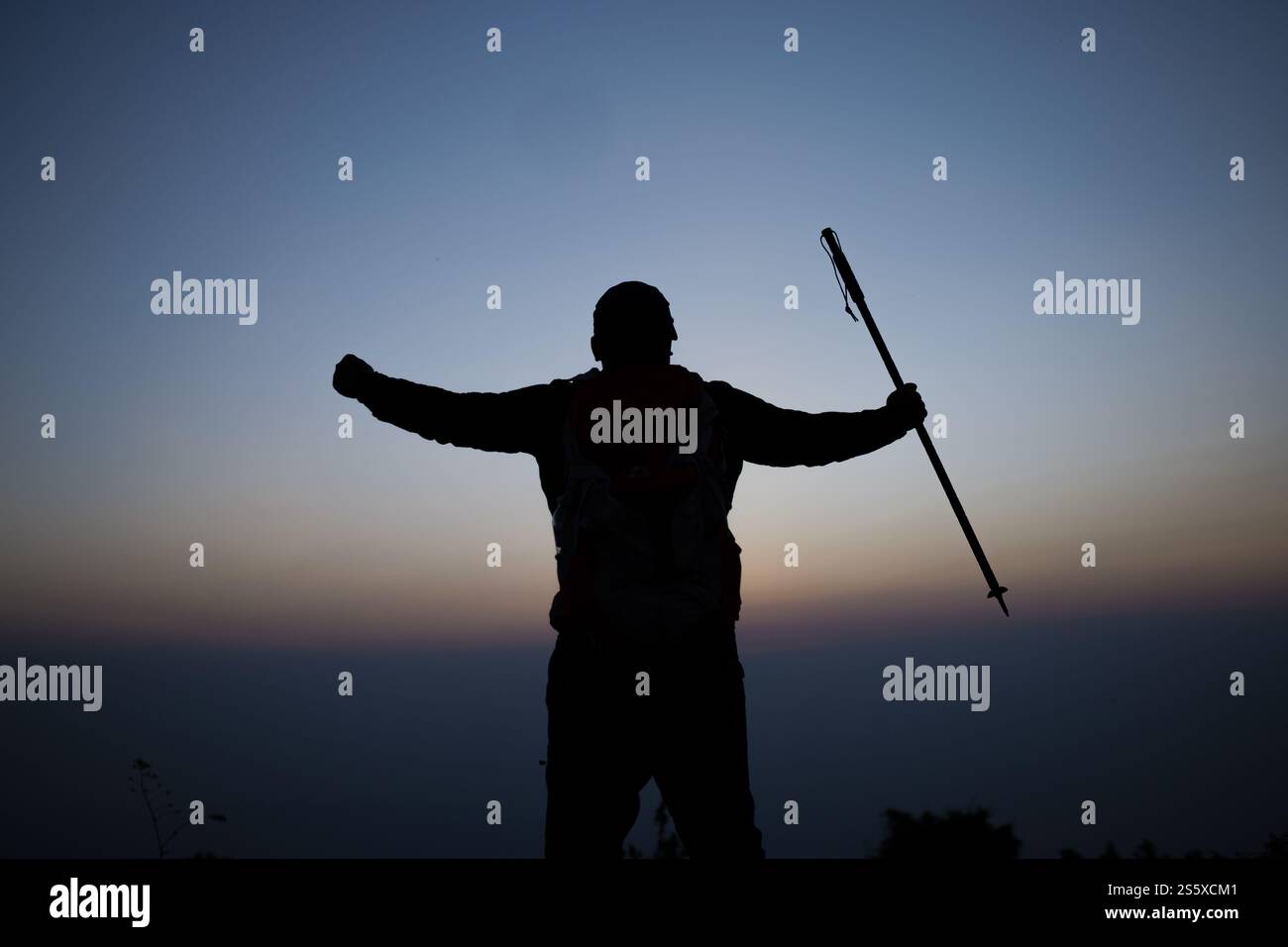 Silhouette di un uomo che fa il tifo per l'escursionismo a braccia aperte fino all'alba sulla montagna. Travel Lifestyle Wanderlust Adventure concept vacanze estive all'aperto. Foto Stock