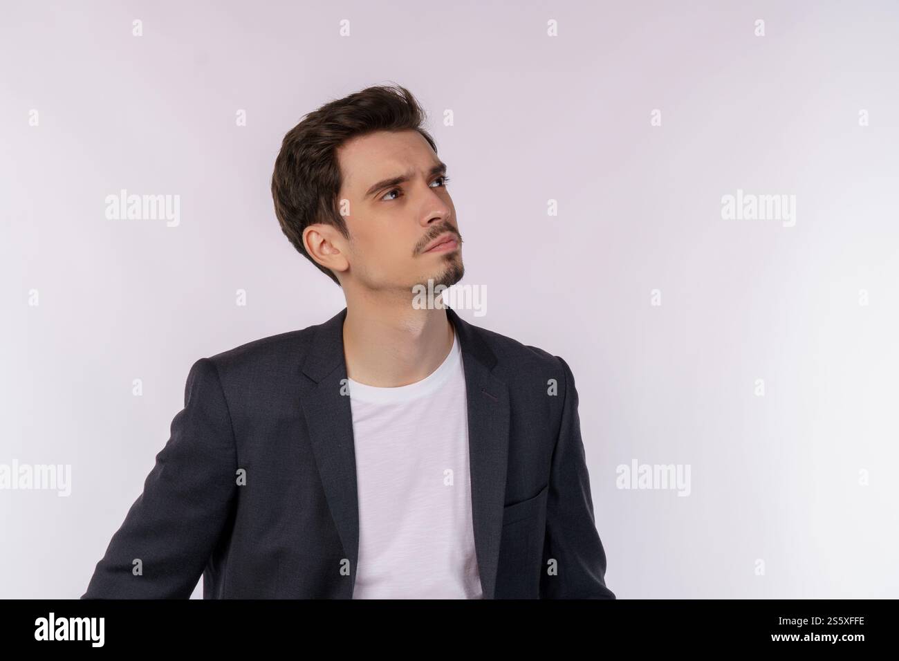 Ritratto dell'uomo pensante circondato da un punto interrogativo su sfondo isolato. Trovare ispirazione o soluzione al problema. Foto Stock