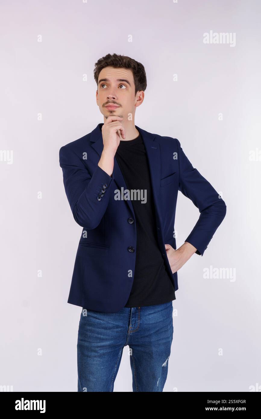 Ritratto di un giovane uomo d'affari che pensa di toccare il mento isolato su sfondo bianco. Pensare preoccupato per una domanda, preoccupato e nervoso Foto Stock