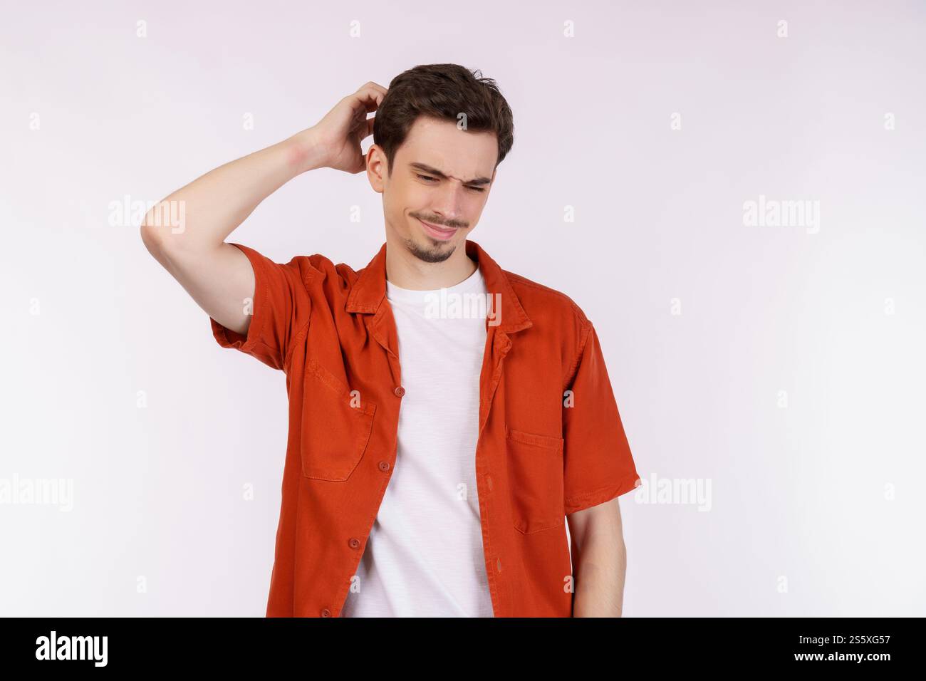 Ritratto dell'uomo pensante circondato da un punto interrogativo su sfondo isolato. Trovare ispirazione o soluzione al problema. Foto Stock