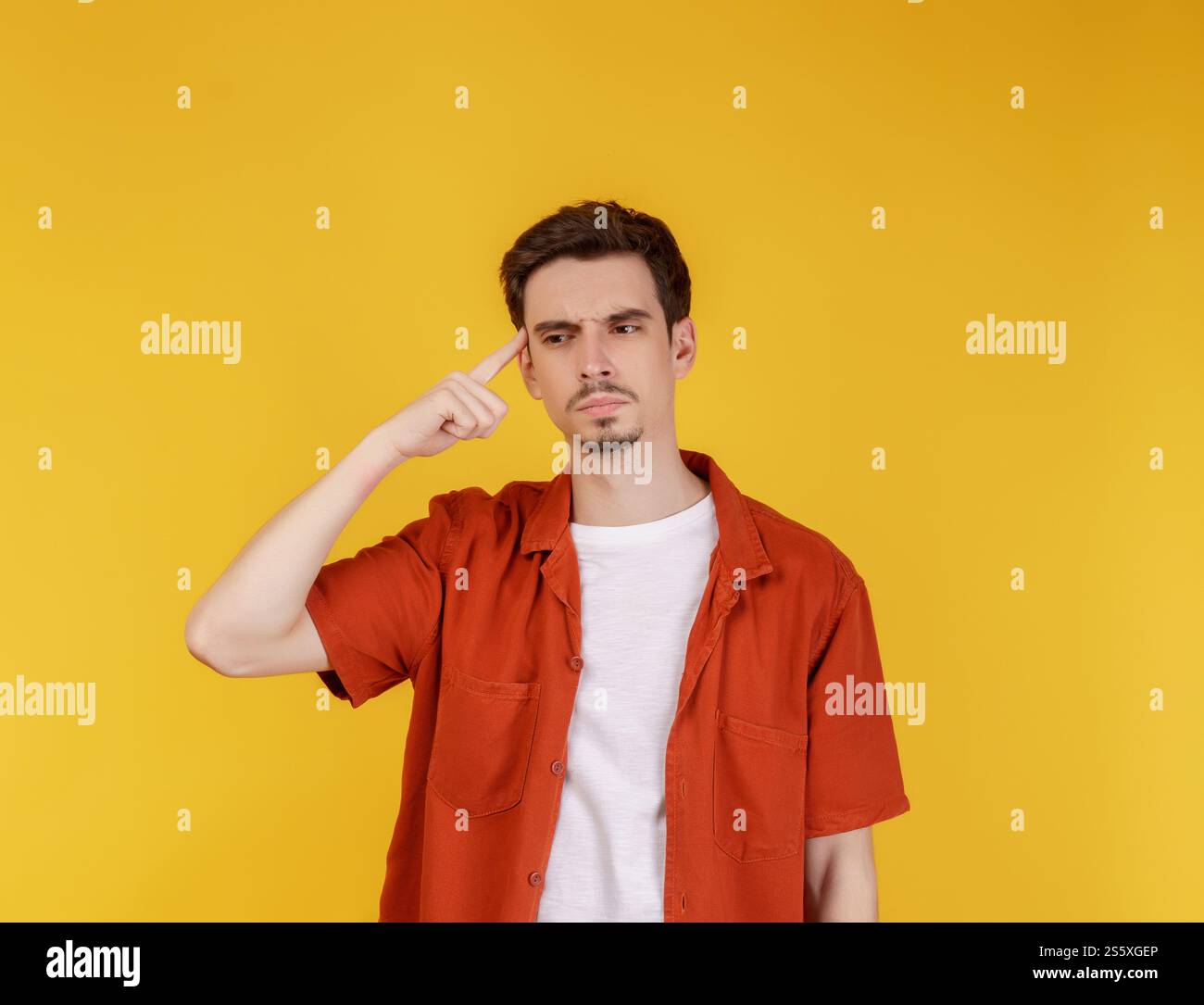 Ritratto dell'uomo pensante circondato da un punto interrogativo su sfondo isolato. Trovare ispirazione o soluzione al problema. Foto Stock