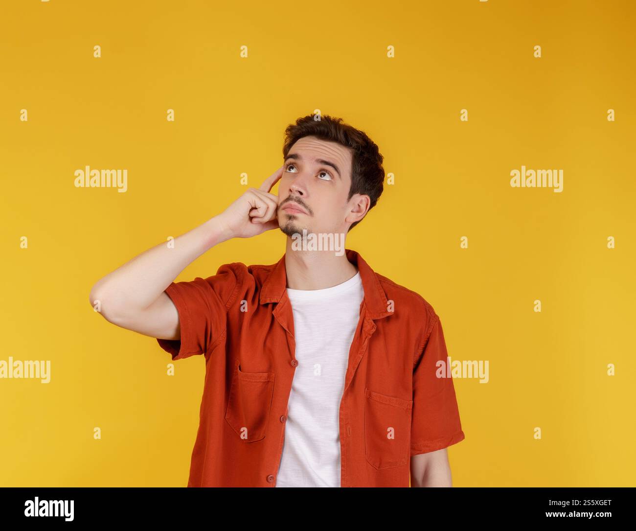 Ritratto dell'uomo pensante circondato da un punto interrogativo su sfondo isolato. Trovare ispirazione o soluzione al problema. Foto Stock