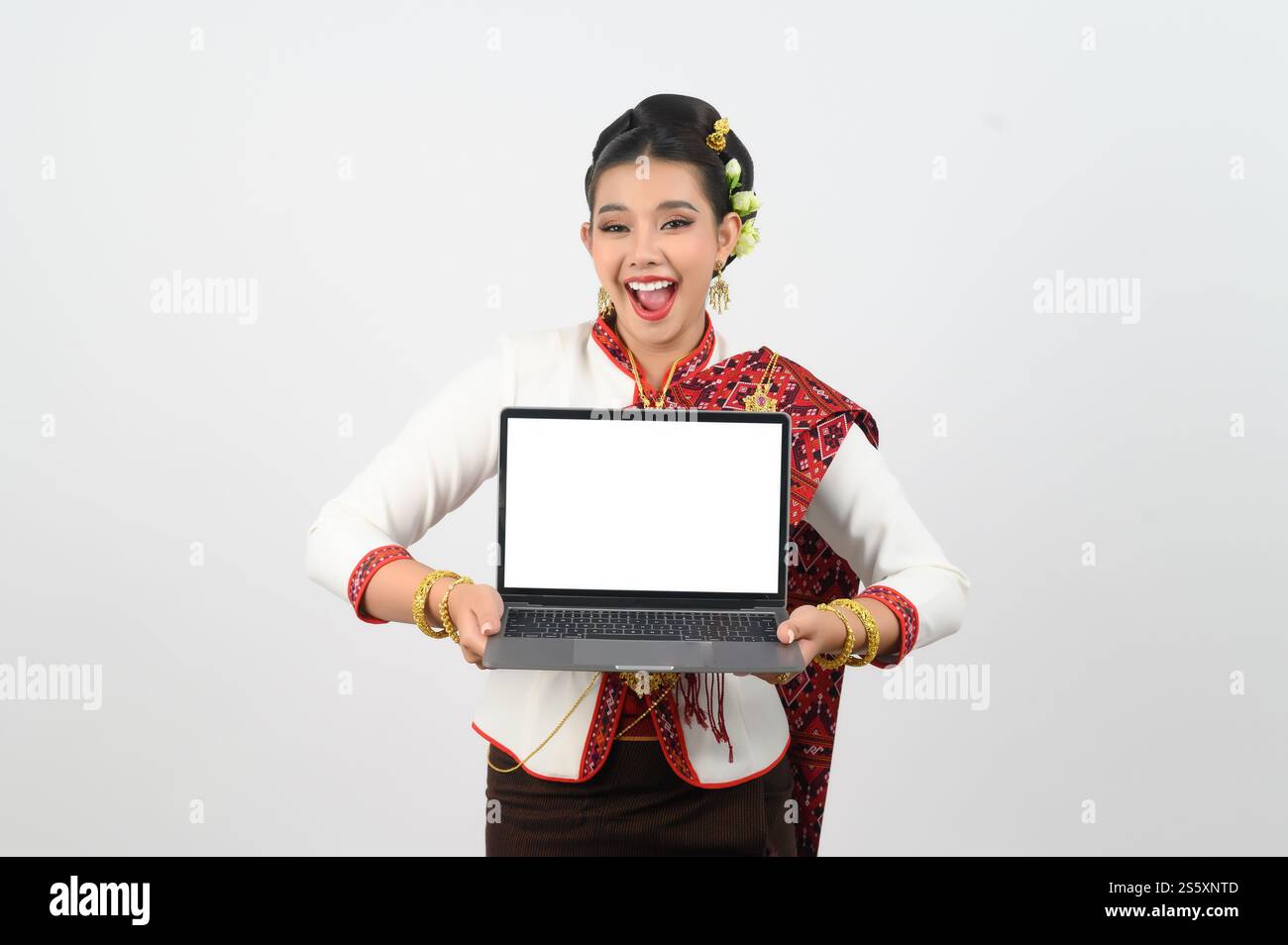 Ritratto di una bella donna in abbigliamento tradizionale del nord tailandese con computer portatile, bella donna asiatica in abito Lanna tailandese che tiene un computer portatile mock-up Foto Stock