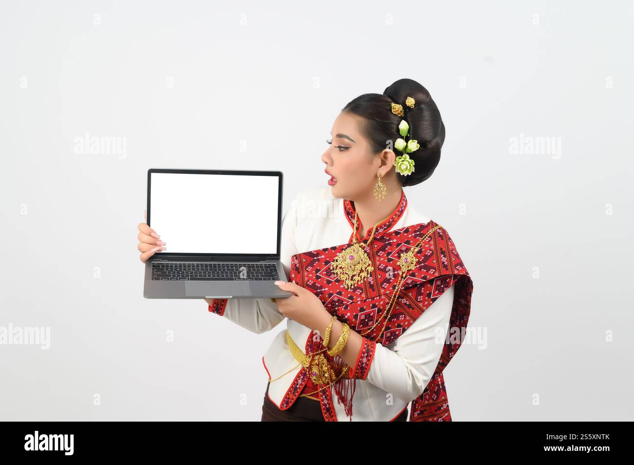 Ritratto di una bella donna in abbigliamento tradizionale del nord tailandese con computer portatile, bella donna asiatica in abito Lanna tailandese che tiene un computer portatile mock-up Foto Stock