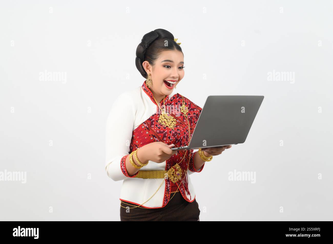Ritratto di una bella donna in abbigliamento tradizionale del nord tailandese con computer portatile, bella donna asiatica in abito Lanna tailandese con laptop in mano Foto Stock