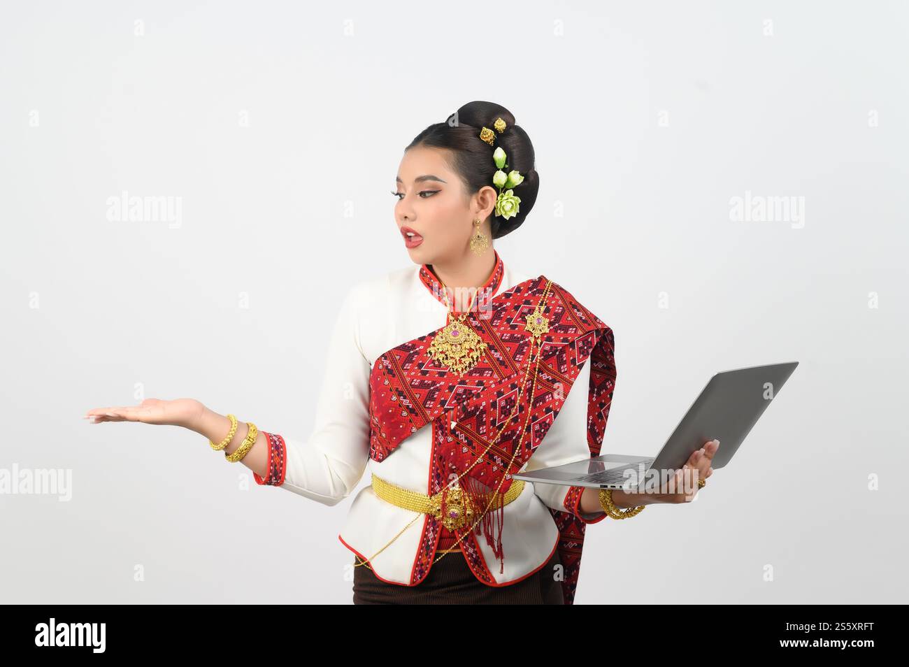 Ritratto di una bella donna in abbigliamento tradizionale del nord tailandese con computer portatile, bella donna asiatica in abito Lanna tailandese con laptop e. Foto Stock