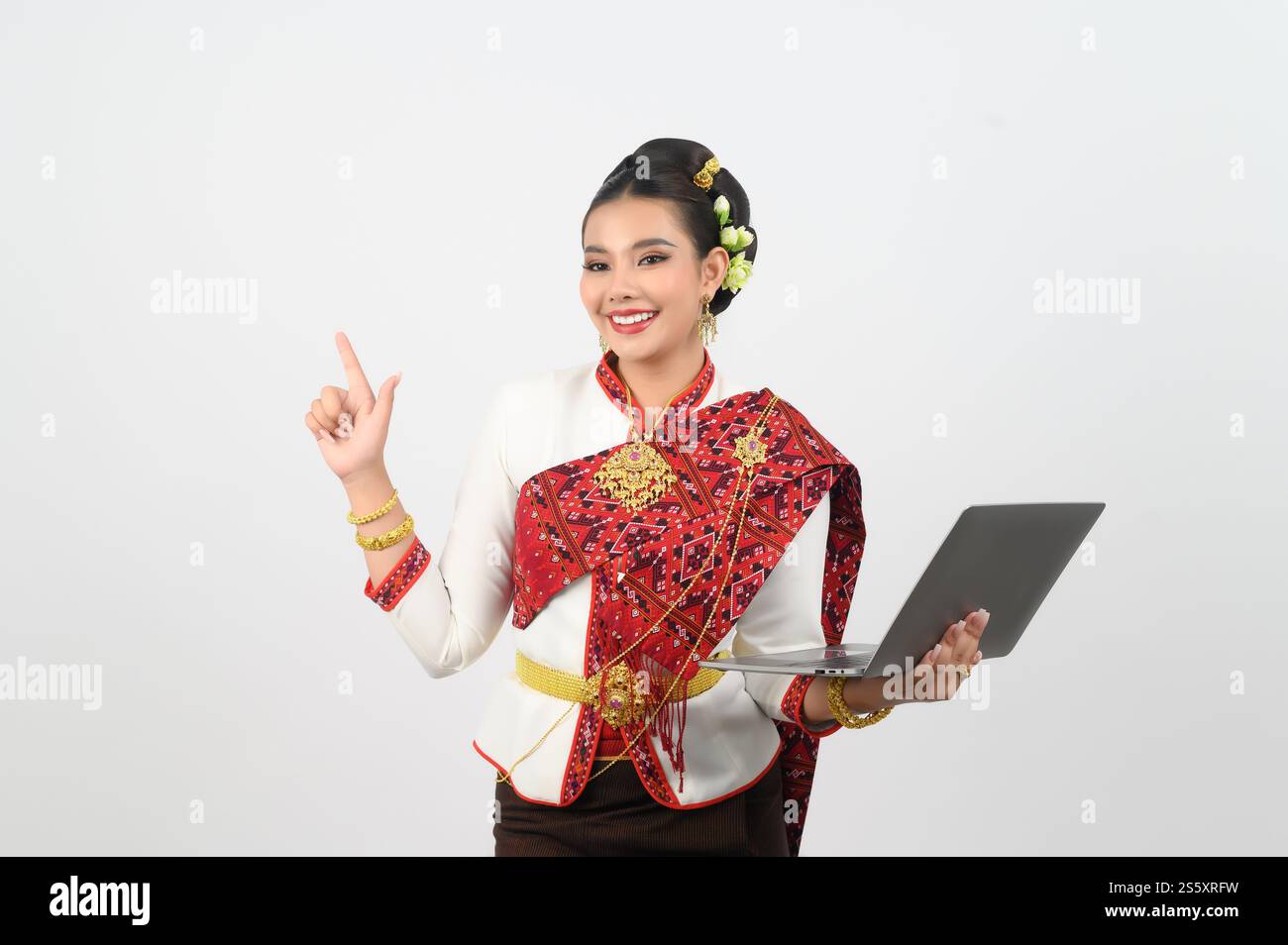 Ritratto di una bella donna in abbigliamento tradizionale del nord tailandese con computer portatile, bella donna asiatica in abito Lanna tailandese con laptop e. Foto Stock