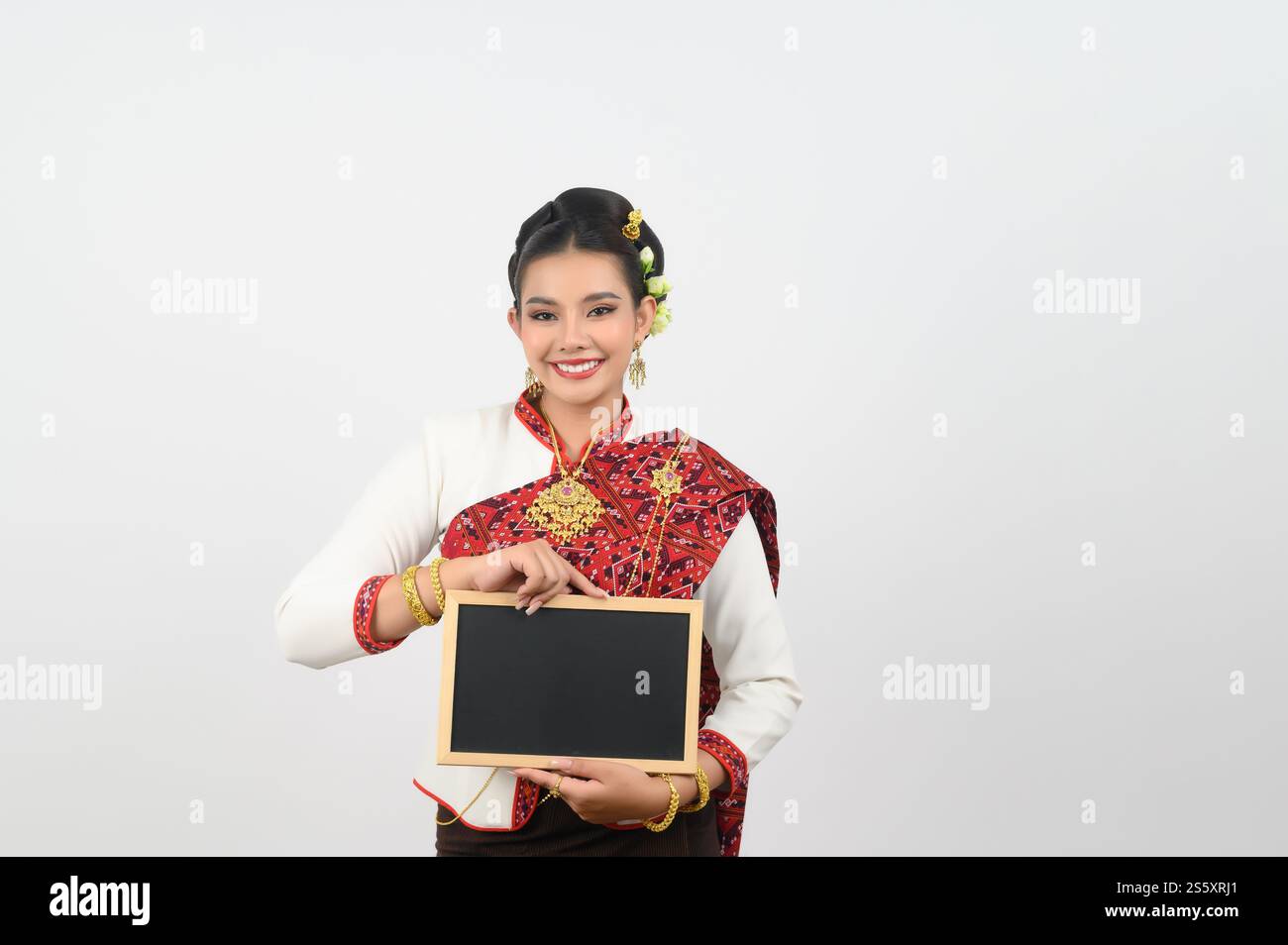 Ritratto di una bella donna in abbigliamento tradizionale thailandese del Nord con lavagna, bella donna asiatica in un abito tailandese Lanna con lavagna vuota Foto Stock