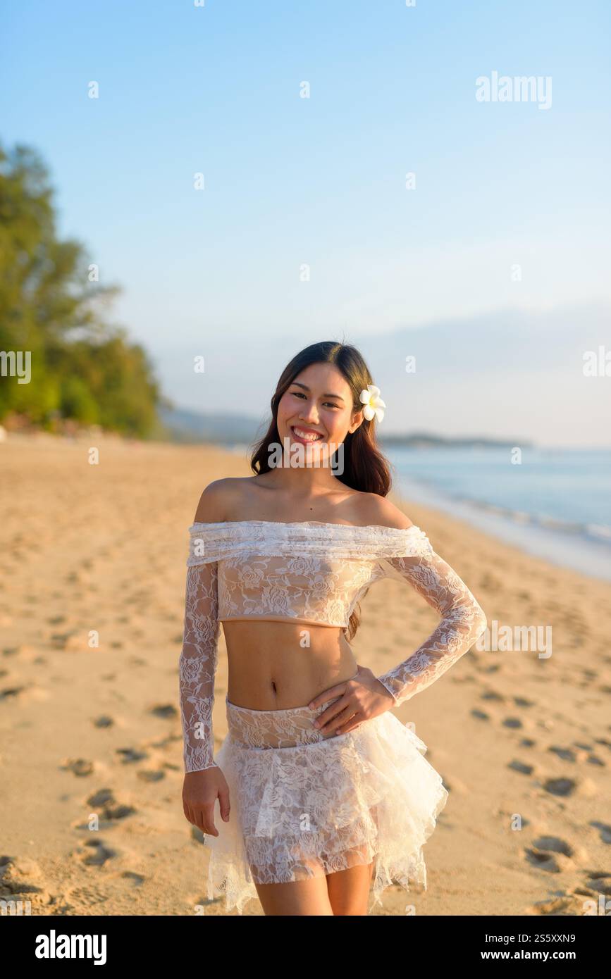 Golden Hour Beauty Concept donna asiatica che gode di un tranquillo tramonto sulla spiaggia Foto Stock