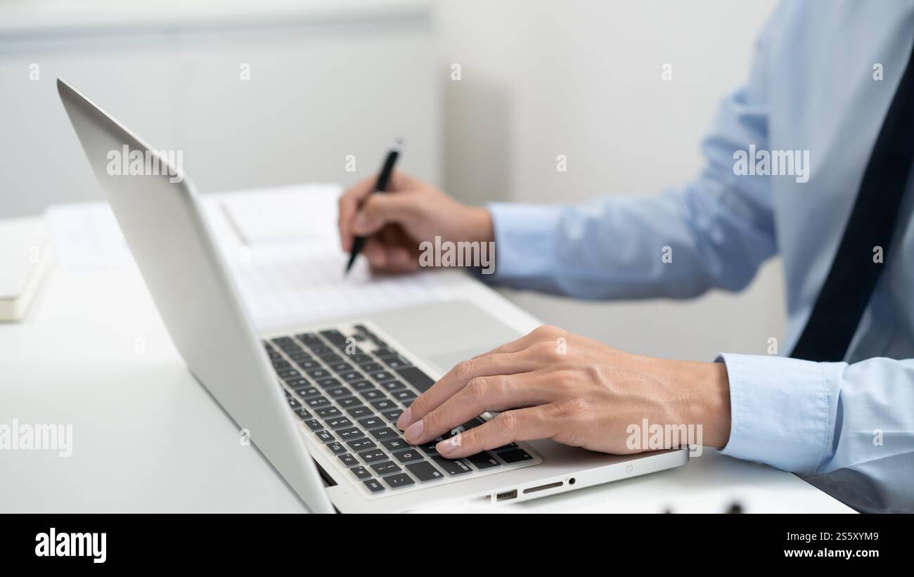 Uomo d'affari che lavora utilizzando le mani del computer portatile digitando su una tastiera. Investitore professionista che lavora per un nuovo progetto di Start-up. pianificazione aziendale in corso Foto Stock