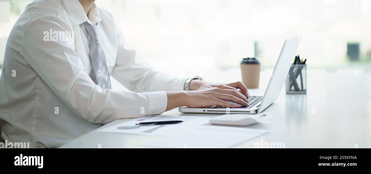 Uomo d'affari che lavora utilizzando le mani del computer portatile digitando su una tastiera. Investitore professionista che lavora per un nuovo progetto di Start-up. pianificazione aziendale in corso Foto Stock