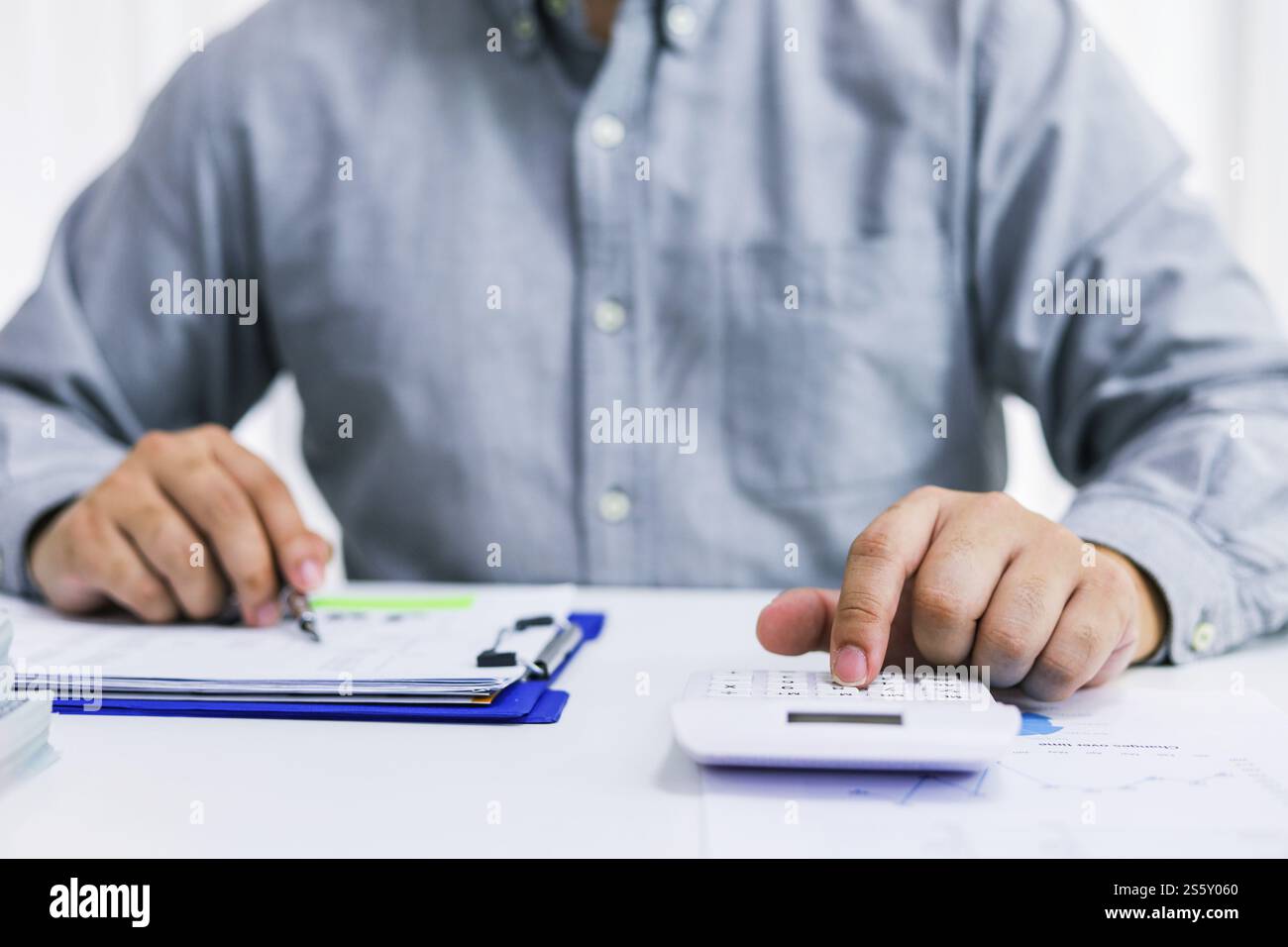 Uomo d'affari che controlla le fatture, le imposte, il saldo del conto bancario e calcola il bilancio annuale della società. Concetto di verifica contabile. Foto Stock