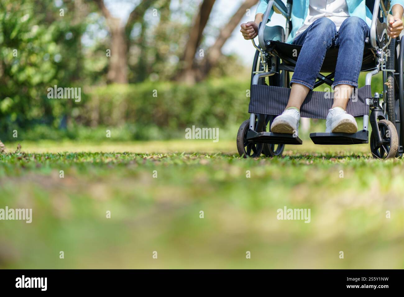 Giovane donna asiatica in sedia a rotelle con pensiero positivo Foto Stock
