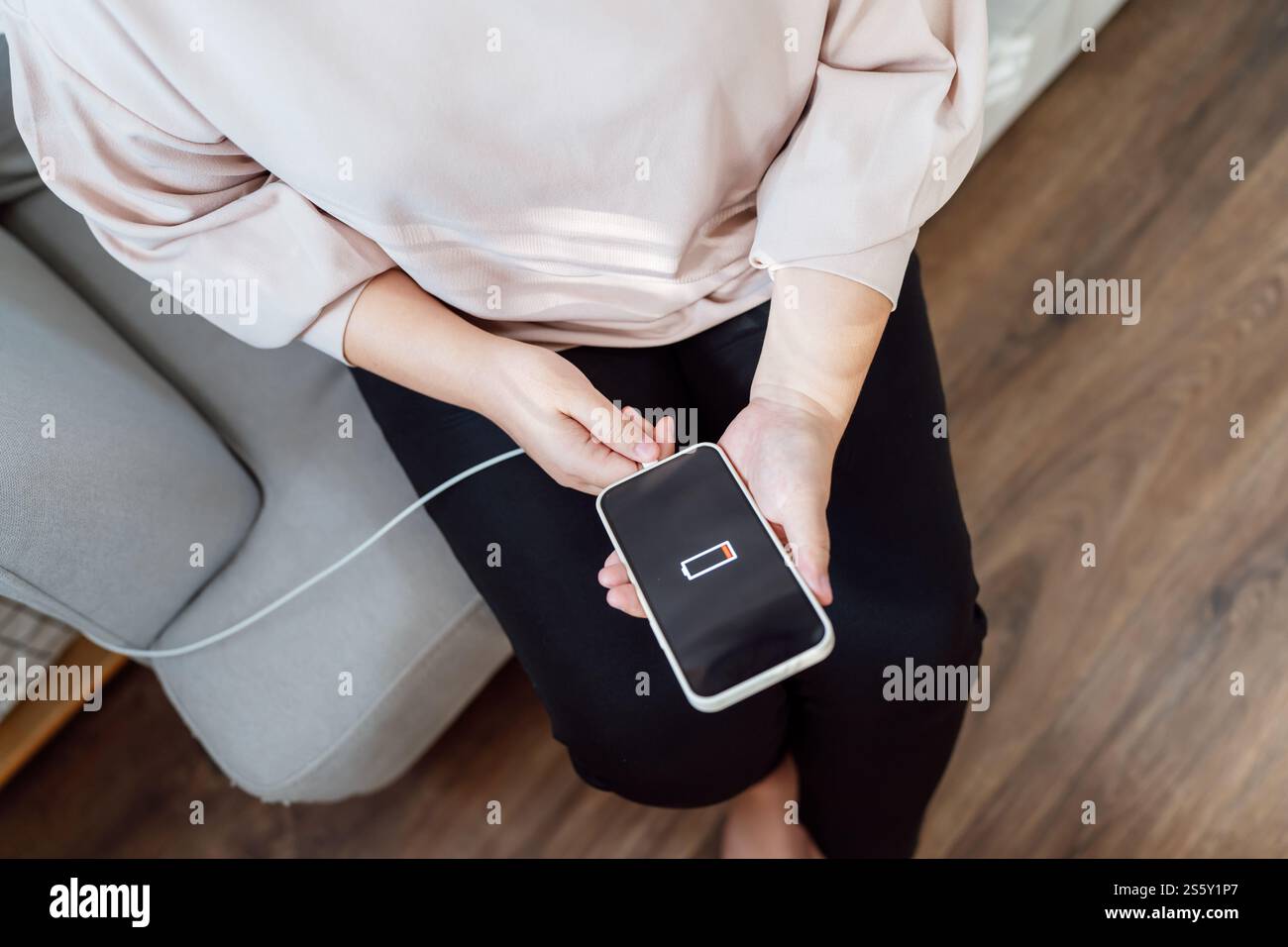 Donna che ricarica la batteria del telefono cellulare con batteria scarica. Collegare un caricabatterie a uno smartphone con un caricabatterie power Bank moderno Foto Stock