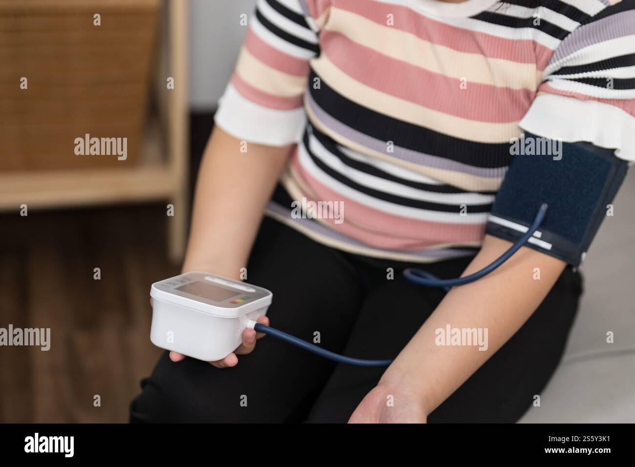 Controllo automatico della pressione sanguigna e della frequenza cardiaca da parte della donna in sovrappeso Plus size. Foto Stock