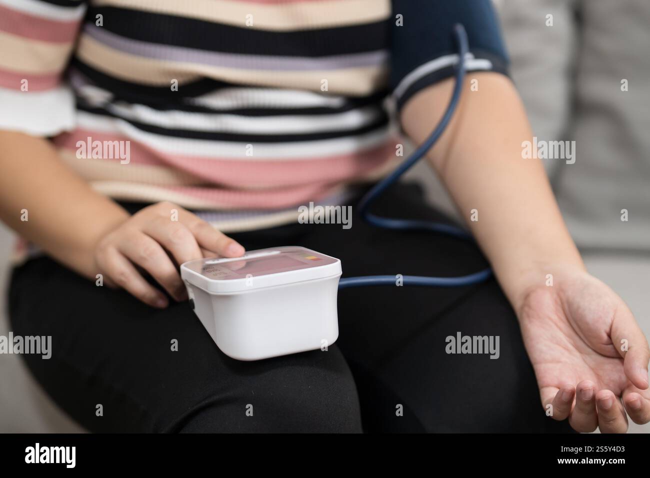 Controllo automatico della pressione sanguigna e della frequenza cardiaca da parte della donna in sovrappeso Plus size. Foto Stock