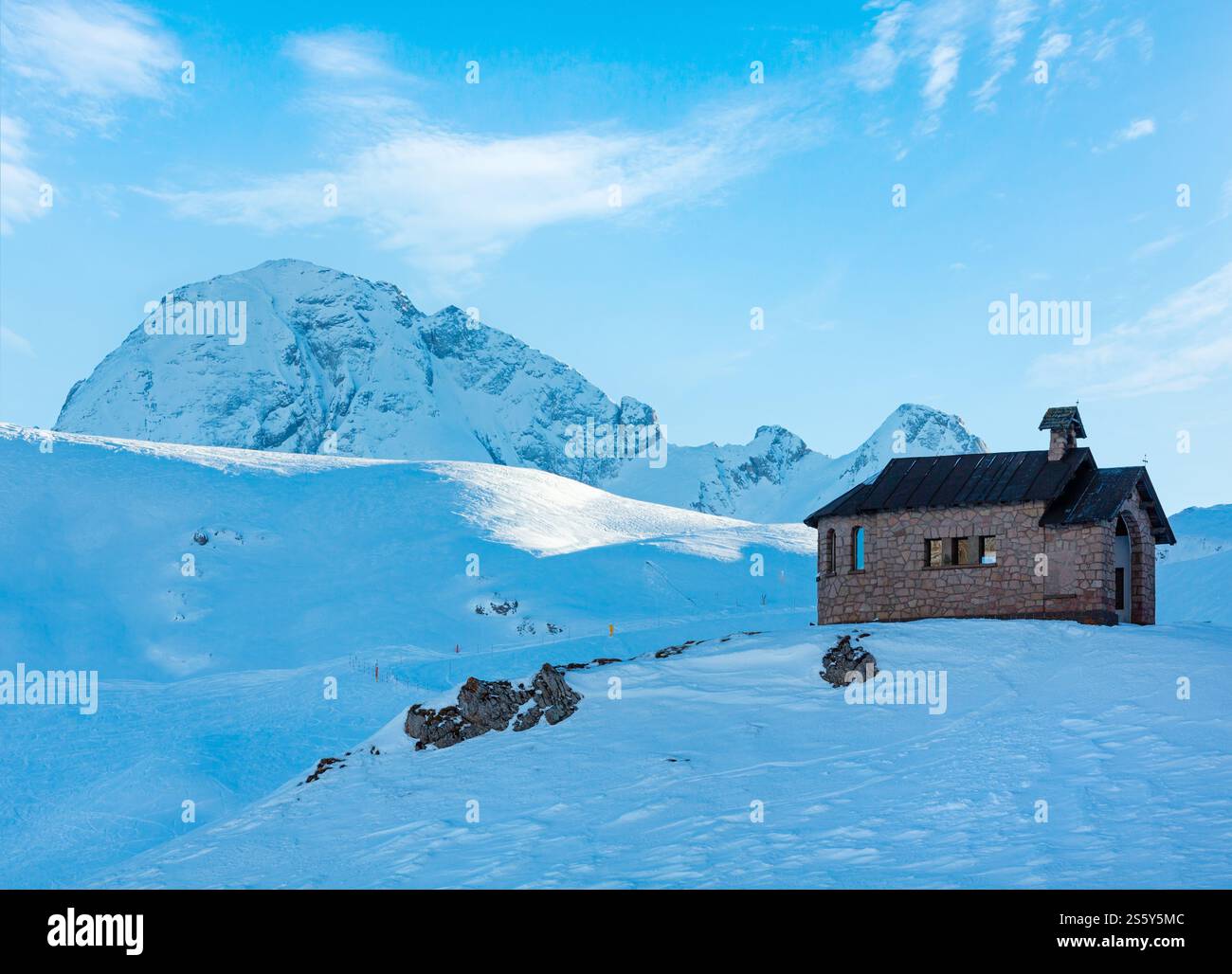 Splendida vista invernale dal passo Pordoi (Dolomiti italiane) con cappella in cima alla collina. Foto Stock