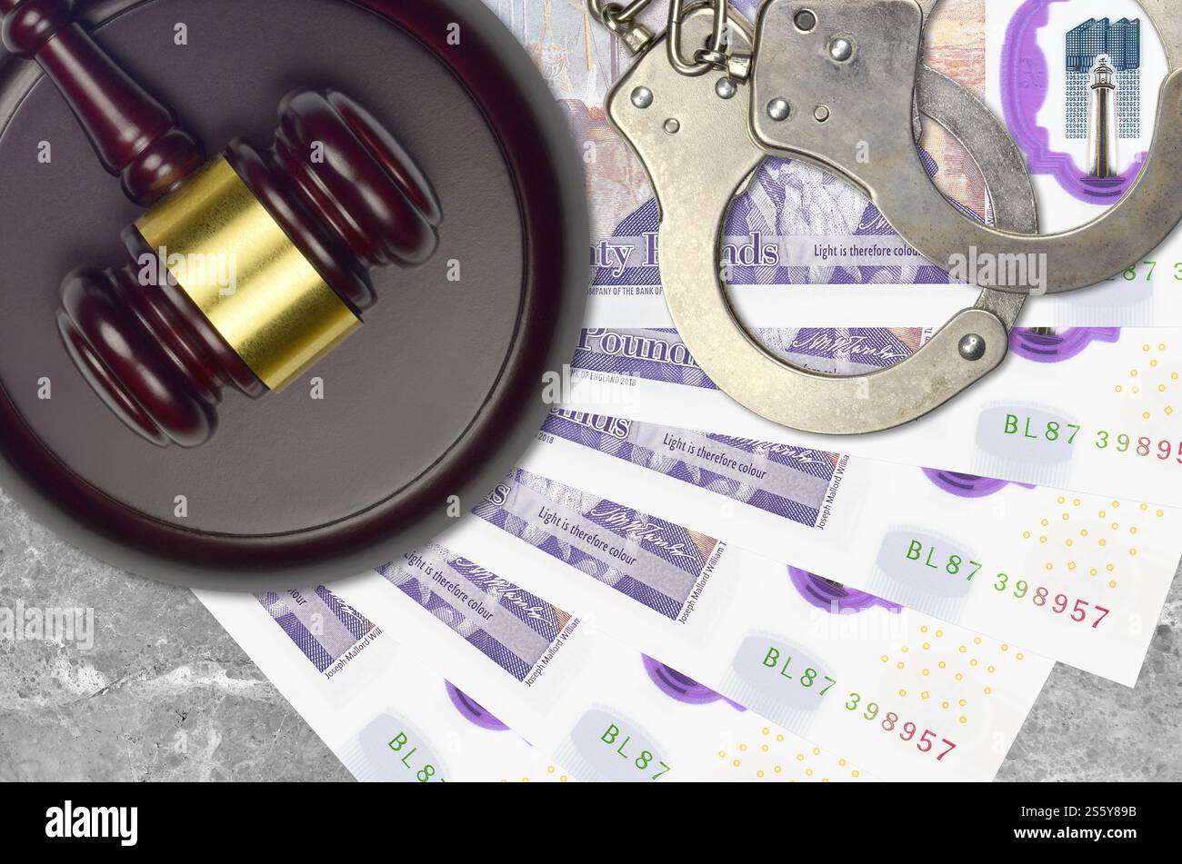 Banconote da 20 sterline britanniche e martello da giudice con manette della polizia sul banco del tribunale. Concetto di processo giudiziario o corruzione. Evasione fiscale o evasione fiscale. 20 Foto Stock